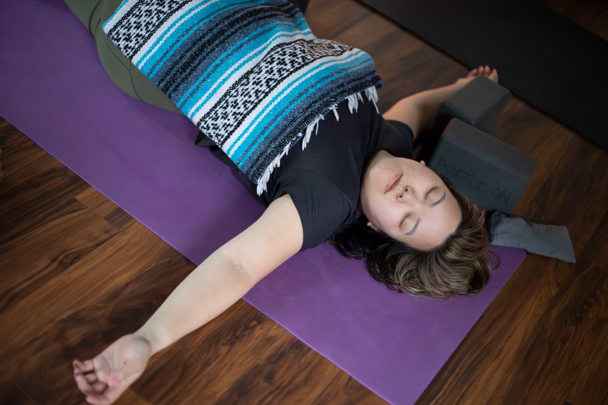 A woman resting in supported savasana during Sleeping Swans